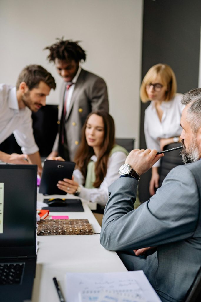 Group of professionals collaborating in a modern office, focusing on teamwork and diversity.